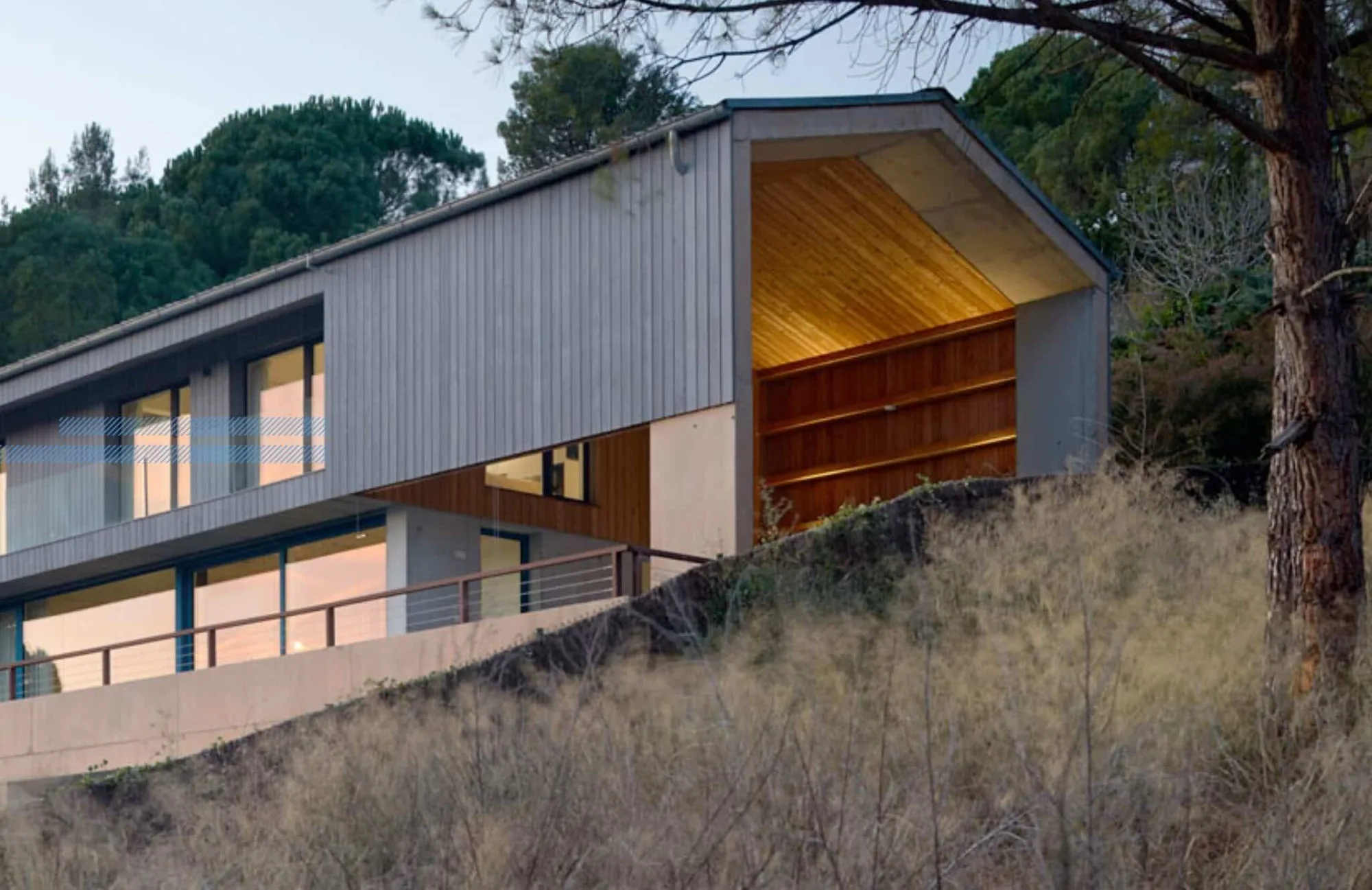 Vivienda Passivhaus con voladizo y alero de madera sobre el porche