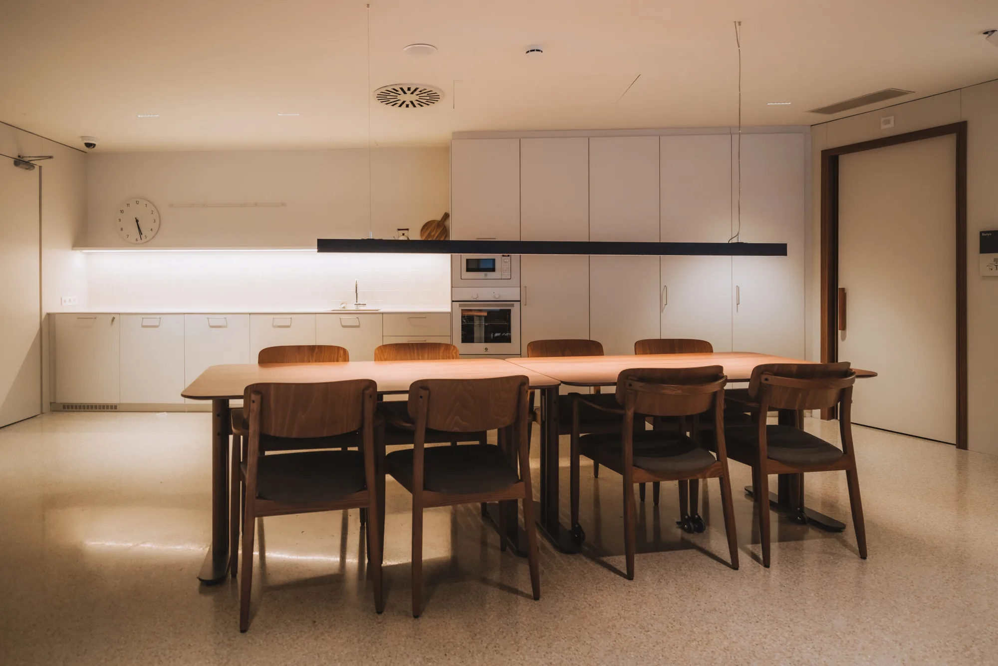 Cocina y comedor de una vivienda Passivhaus, con mesa de madera y luz uniforme