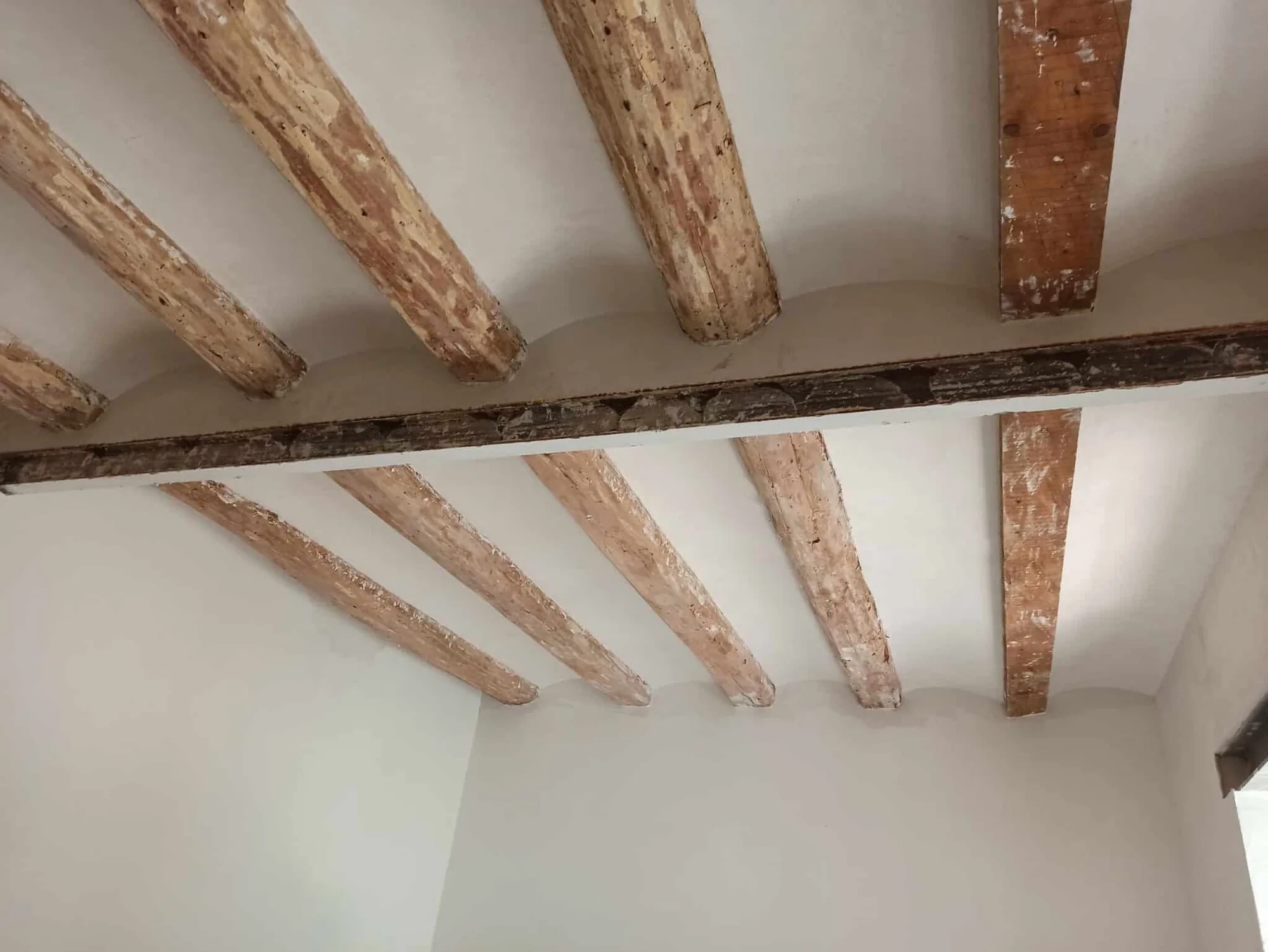 Interior rehabilitado con la estructura de vigas de madera original a la vista